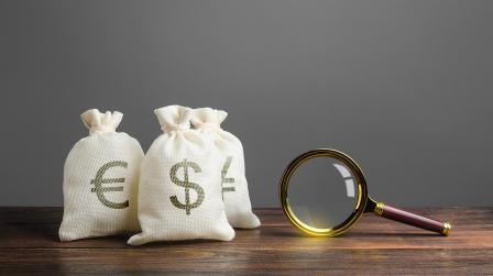 Three,Bags,Of,Money,And,A,Magnifying,Glass.,Search,For