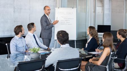 Confident,Mature,Businessman,Giving,A,Presentation,To,His,Team,In