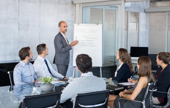 Confident,Mature,Businessman,Giving,A,Presentation,To,His,Team,In