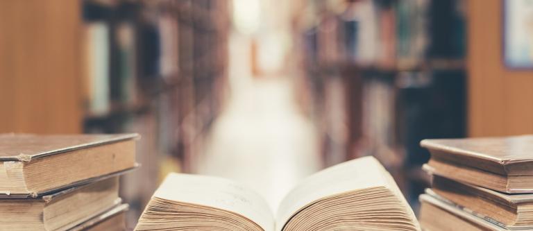 Old,Book,In,Library,With,Open,Textbook,,Stack,Piles,Of